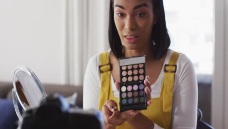 Mixed-race-gender-fluid-vlogger-recording-a-make-up-vlog-at-home