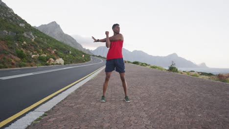 African-american-man-performing-stretching-his-arms-while-standing-on-the-road