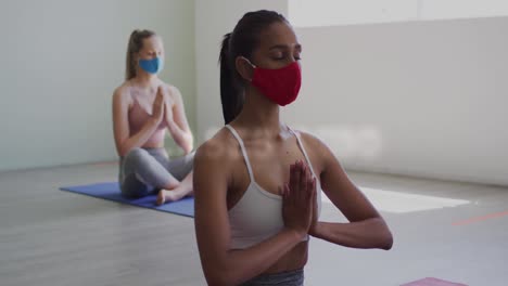 Coronavirus-Konzepttexte-Gegen-Zwei-Frauen,-Die-Gesichtsmasken-Tragen-Und-Yoga-Praktizieren