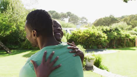 Happy-african-american-couple-hugging-in-sunny-garden-and-smiling
