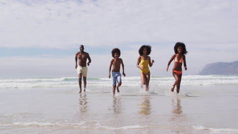 Afroamerikanische-Eltern-Und-Zwei-Kinder-Laufen-Am-Strand
