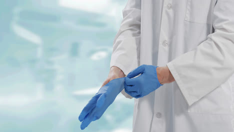 Mid-section-of-male-doctor-wearing-surgical-gloves-against-white-background