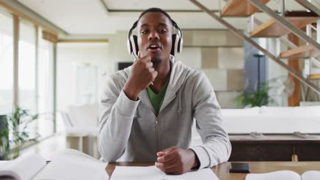 African-american-male-teenager-wearing-headphones-having-a-video-conversation