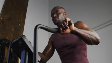 Fit-african-american-man-exercising-on-training-bike-inside-gym