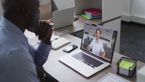 African-american-senior-man-having-a-video-call-with-male-colleague-on-laptop-at-office