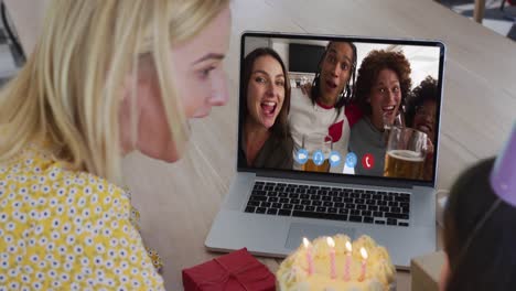 Caucasian-mother-and-daughter-sitting-at-table-using-laptop-having-birthday-video-call