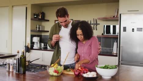Glückliches,-Vielfältiges-Paar,-Das-Gemeinsam-In-Der-Küche-Essen-Zubereitet-Und-Gemüse-Für-Den-Salat-Hackt