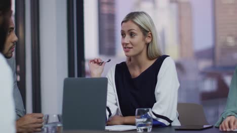 Video-of-caucasian-businesswoman-talking-to-colleagues-at-office-meeting