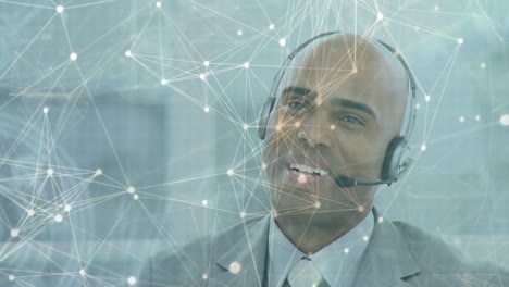 Animation-of-network-of-connections-over-businessman-with-headset-in-office