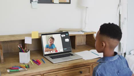 African-american-boy-raising-his-hands-while-having-a-video-call-on-laptop-at-home