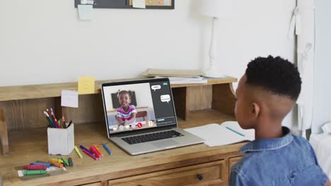 African-american-boy-raising-his-hands-while-having-a-video-call-on-laptop-at-home