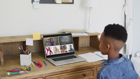 African-american-boy-raising-his-hands-while-having-a-video-conference-on-laptop-at-home