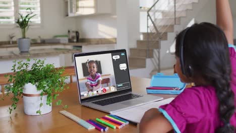 African-american-girl-having-a-video-call-with-classmate-on-laptop-at-home
