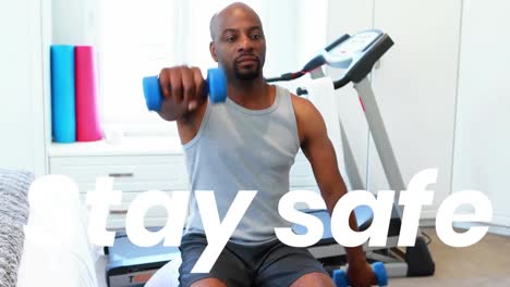 Stay-safe-text-against-african-american-man-working-out-with-dumbbells-at-home