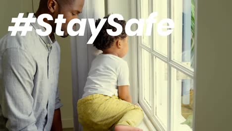 Animation-of-stay-safe-text-over-father-and-child-at-home