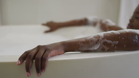 African-american-attractive-woman-relaxing-in-foam-bath-in-bathroom
