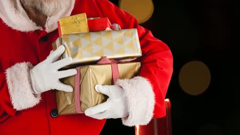 Animation-of-santa-claus-holding-christmas-presents-over-orange-spots-of-light