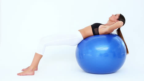 Fit-woman-doing-sit-ups-on-blue-exercise-ball