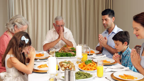 Familia-Extendida-Orando-Antes-De-La-Cena
