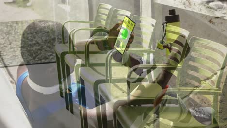 Afroamerikanischer-Mann-Benutzt-Smartphone-Mit-QR-Code-Auf-Dem-Bildschirm-Gegen-Leere-Stühle-Im-Krankenhaus