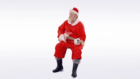 Snow-falling-over-santa-claus-playing-an-electric-guitar-against-grey-background