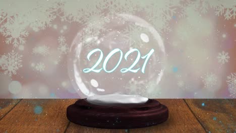 Blue-shooting-star-around-2021-text-over-a-snow-globe-on-wooden-plank