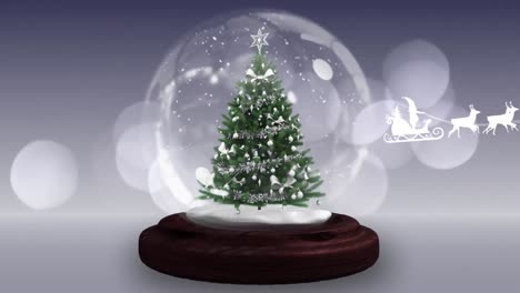 Santa-claus-in-sleigh-being-pulled-by-reindeers-against-christmas-tree-in-a-snow-globe