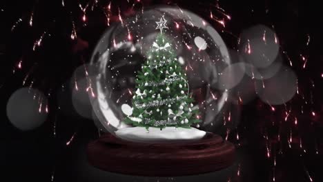 Shooting-star-around-christmas-tree-in-a-snow-globe-against-fireworks-exploding-on-black-background