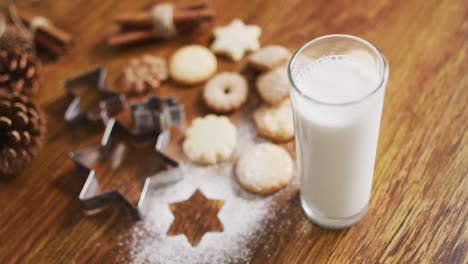 Video-of-christmas-decorations-with-glass-of-milk-and-cookies-on-wooden-background