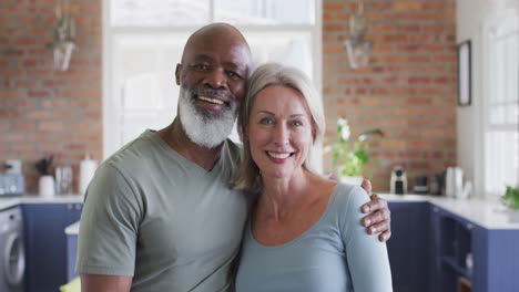 Portrait-of-mixed-race-senior-couple-smiling-at-home