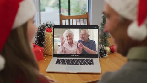 Kaukasischer-Großvater-Und-Enkelin-Bei-Einem-Videoanruf-Auf-Dem-Laptop-Mit-älteren-Freunden-Zu-Weihnachten