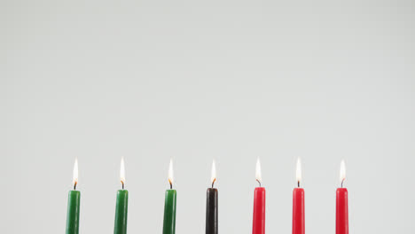 Mehrere-Bunte-Brennende-Kerzen-Und-Zwei-Kürbisse-Vor-Grauem-Hintergrund