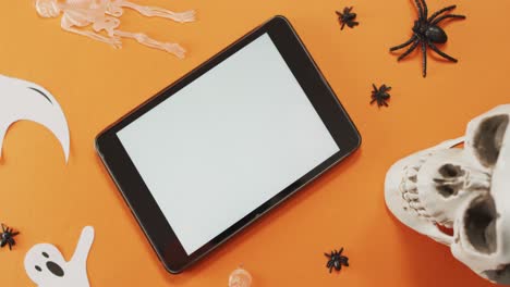 Nahaufnahme-Von-Halloween-Spielzeug-Und-Digitalem-Tablet-Mit-Kopierraum-Vor-Orangefarbenem-Hintergrund