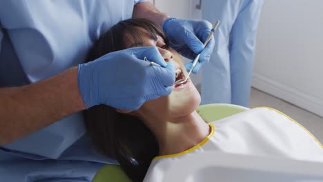 Kaukasischer-Männlicher-Zahnarzt-Und-Zahnpfleger-Untersuchen-Die-Zähne-Einer-Patientin-In-Einer-Modernen-Zahnklinik