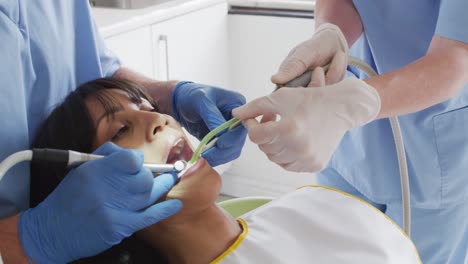 Hände-Eines-Männlichen-Zahnarztes-Mit-Einer-Zahnärztin,-Die-Die-Zähne-Einer-Patientin-In-Einer-Modernen-Zahnklinik-Untersucht