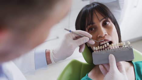 Kaukasischer-Männlicher-Zahnarzt,-Der-Die-Zähne-Einer-Patientin-In-Einer-Modernen-Zahnklinik-Untersucht