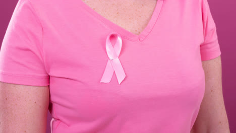 Video-of-midsection-of-caucasian-woman-wearing-pink-cancer-awareness-ribbon