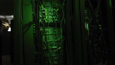 Green-control-lights-and-multiple-cables-on-computer-servers-in-tech-room