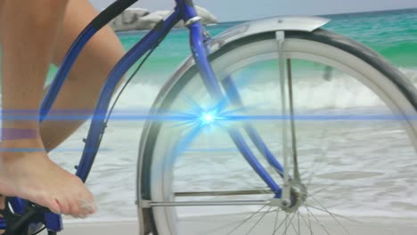 Animation-of-blue-light-beam-moving-over-bare-feet-of-man-riding-bicycle-on-beach