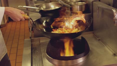 Chef-tossing-stir-fry-over-large-flame