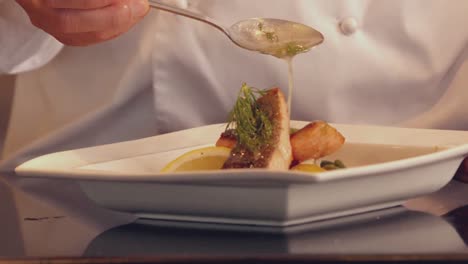 Chef-pouring-sauce-over-fish-dish