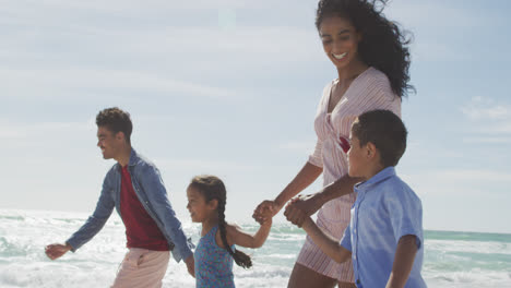 Happy-hispanic-mother,-father,-son-and-daughter-walking-on-beach