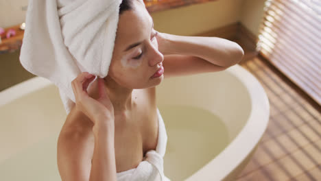 Biracial-woman-with-vitiligo-wearing-towel-on-hair-relaxing-in-bath