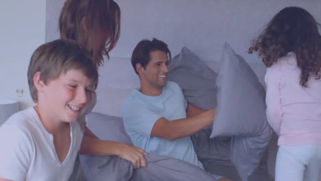 Animation-of-retro-boom-text-over-caucasian-parents-with-two-children-pillow-fighting