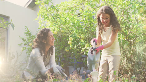 Video-of-lights-over-happy-biracial-woman-and-girl-watering-garden