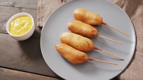 Video-of-corn-dogs-with-dips-on-a-wooden-surface