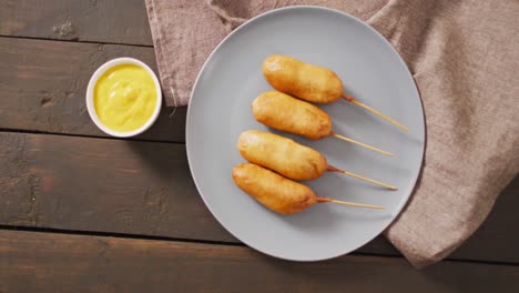 Video-of-corn-dogs-with-dips-on-a-wooden-surface