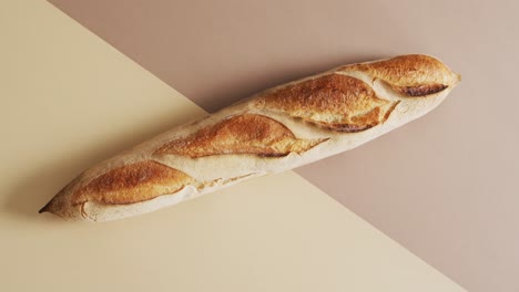 Video-of-one-baguette-on-a-brown-and-beige-surface