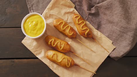 Video-of-corn-dogs-with-dip-on-a-wooden-surface