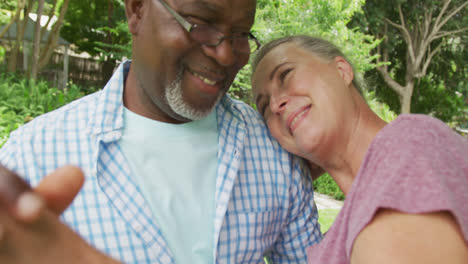 Happy-senior-diverse-couple-wearing-shirts-and-embracing-in-garden